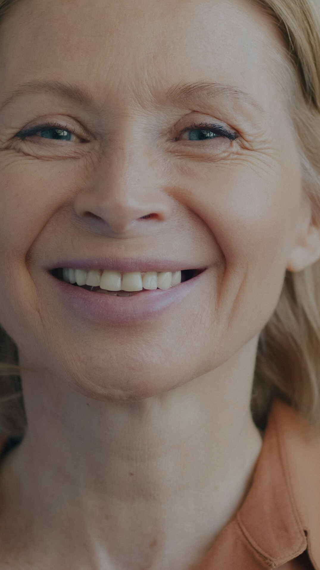 Studio portrait of a Belgian woman in her 40s with short brown hair smiling